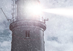 lighthouse shining into storm