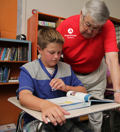 Male Foster Grandparent helping student with homework