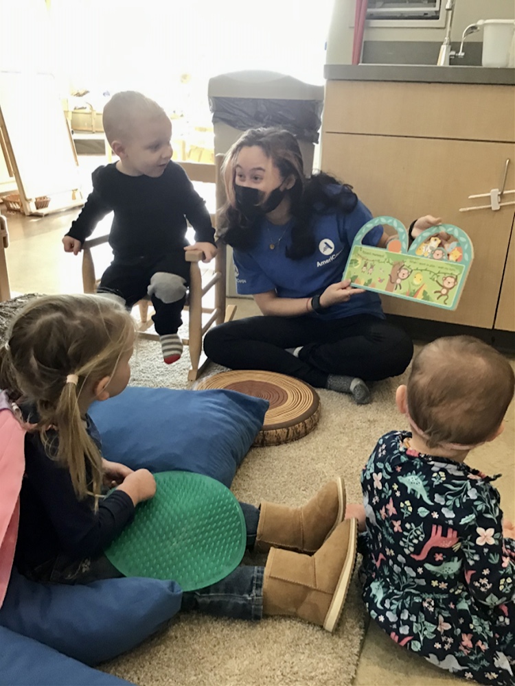 Teacher reads a book to a classroom of students