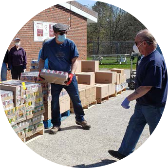 Photo of two individuals moving donations off of a pallet.