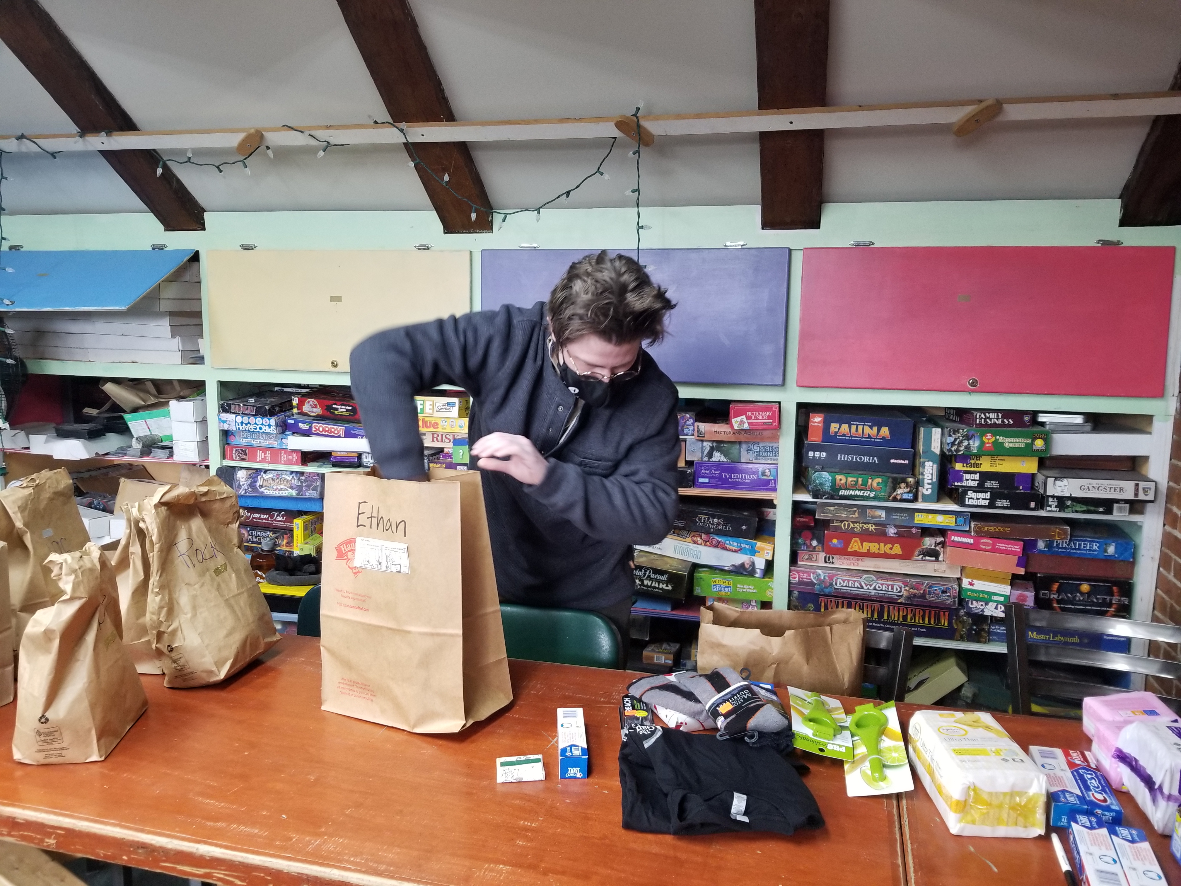 Person bagging goods in a paper bag