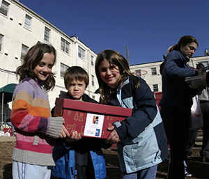 three grade school students moving a box of donations on Martin Luther King Day of Service