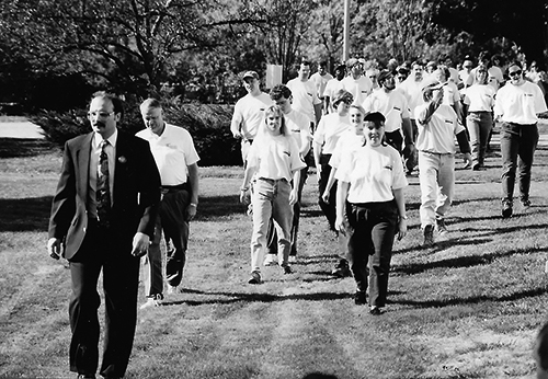 a crowd of people walking onto Blaine House grounds, parade style